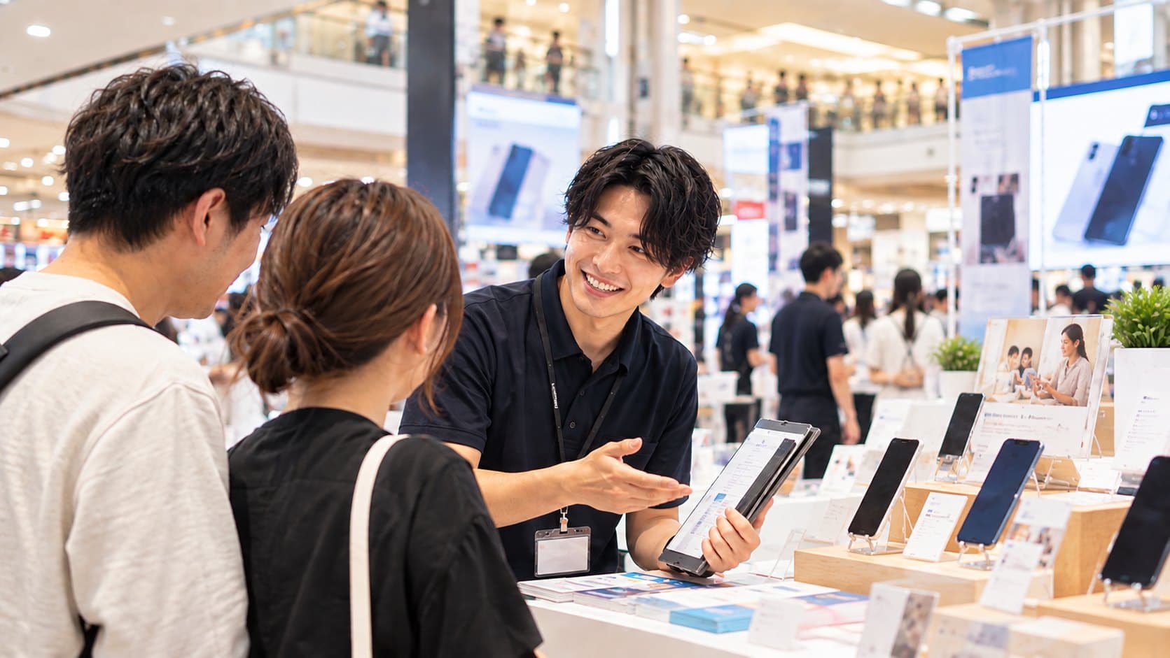家電量販店の通信イベントブースでの接客風景